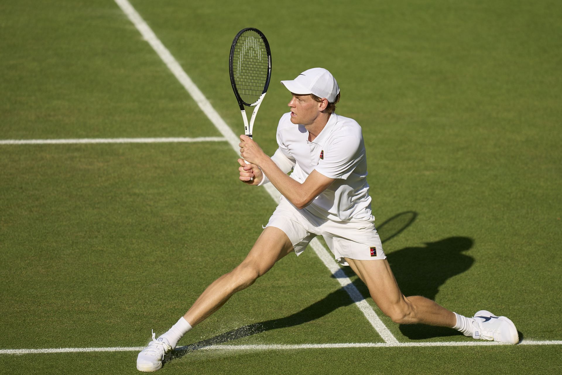Jannik Sinner plays a sliding two-handed backhanded at the 2025 Wimbledon Championships (Source: Getty)
